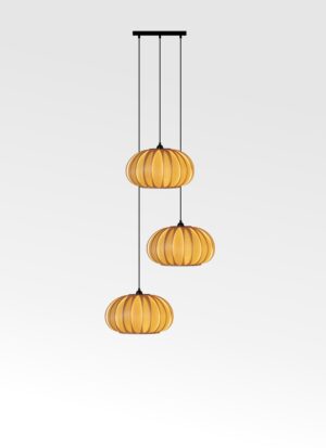 Handmade baby pumpkin cluster pendant glowing above a table.